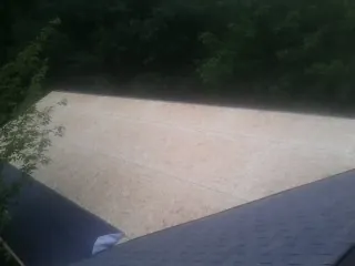 New OSB roof sheathing installed beside an existing shingle roof in Fort Hood