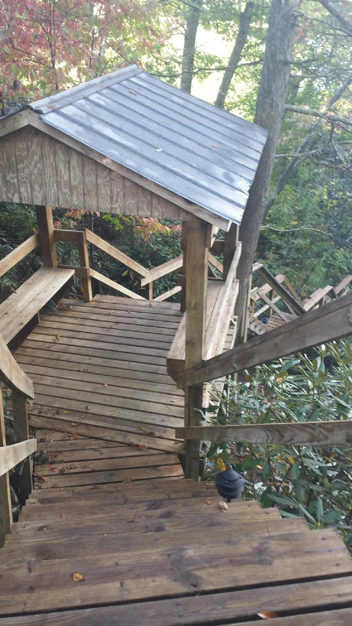 Metal roofed shelter over wooden steps on a wooded walkway — Skylight Repair & Installation work by our crew in Fort Hood