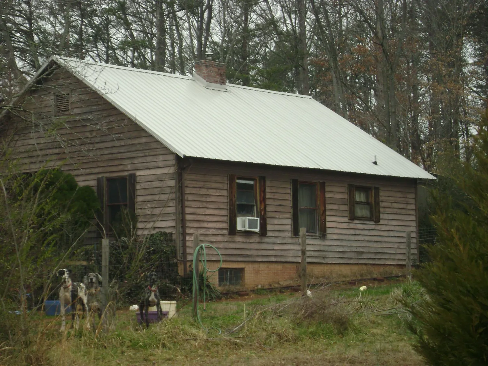 White metal roof on an old wood sided farmhouse, from a Asphalt Shingle Roof Repair job in Fort Hood